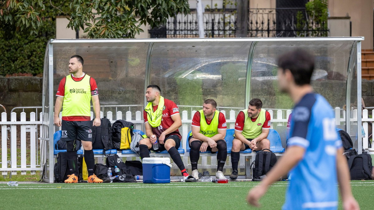 Soccer players sitting on the bench during a game