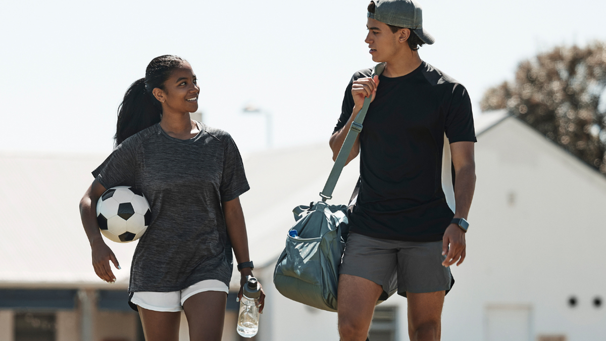 Soccer players walking with gear after practice