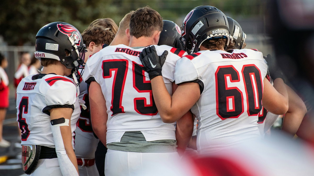 Football teammates supporting each other in a huddle