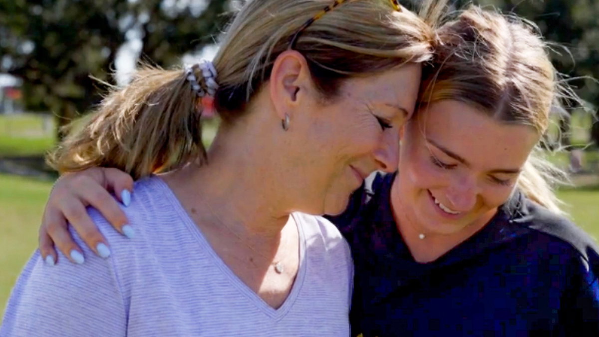 Two athletes walking arm in arm in support
