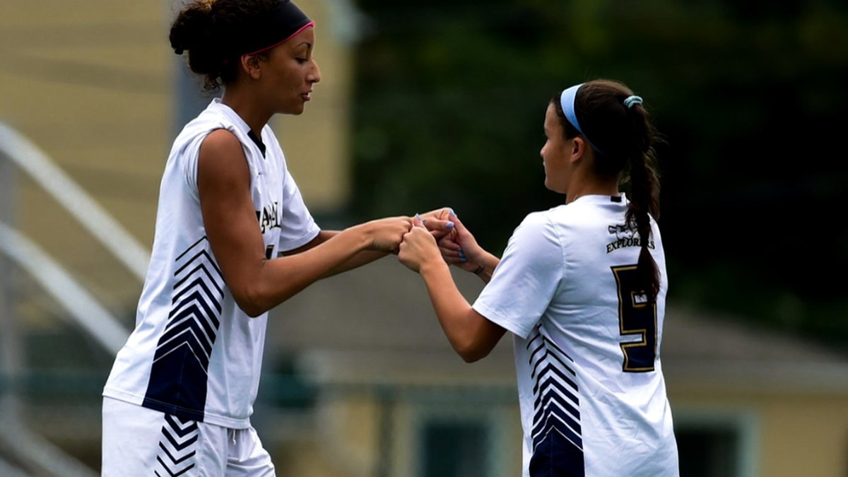 Two athletes tapping hands in support