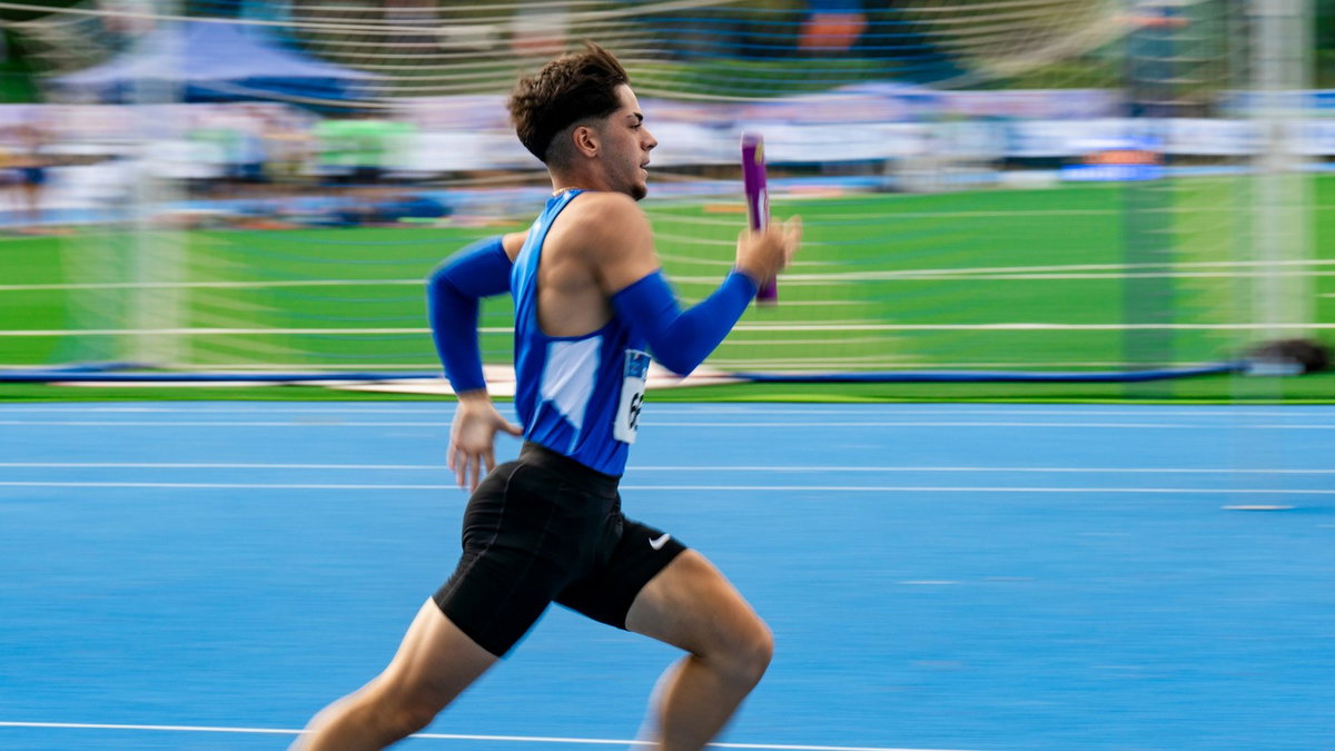 Relay runner holding a baton during a race